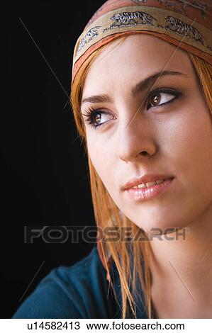 Stock Image - Woman wearing cap looking off to side. Fotosearch
