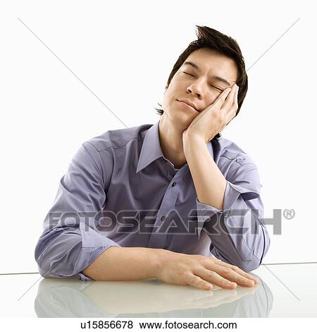 Young Asian business man sitting resting his eyes. View Large Photo Image Stock Photo - Young Asian business man sitting resting his eyes.. Fotosearch