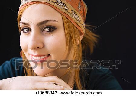 Stock Photo - Young redheaded woman wearing cap smiling at viewer. Fotosearch