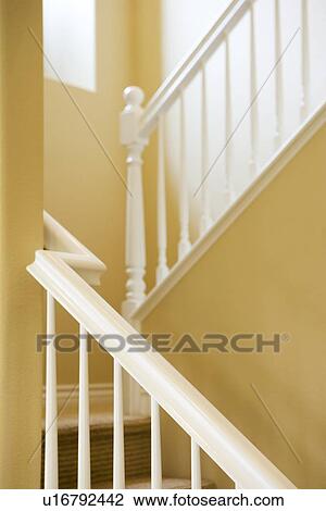 Stock Image - Architectural detail staircase railing and yellow wall. Fotosearch