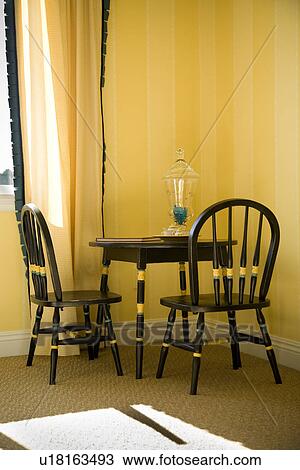 Stock Image - Black play table and chairs in corner of yellow room. Fotosearch