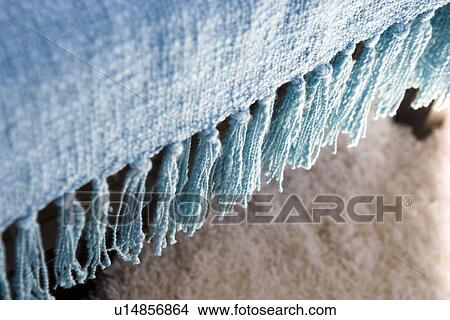 Blue throw blanket with tassels hanging over chair View Large Photo Image Picture - Blue throw blanket with tassels hanging over chair. Fotosearch