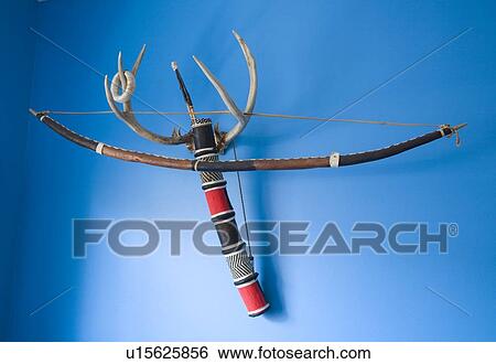 Bow and arrows hanging on antlers on blue wall View Large Photo Image Stock Photograph - Bow and arrows hanging on antlers on blue wall. Fotosearch