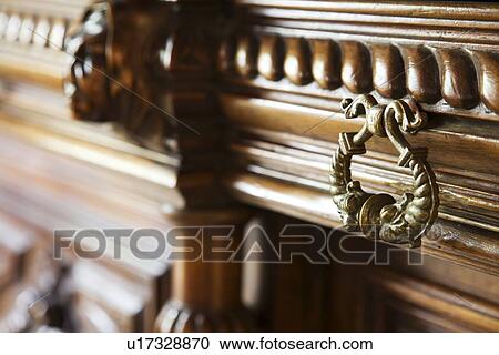 Stock Image - Bronze drawer handle on wooden drawer. Fotosearch