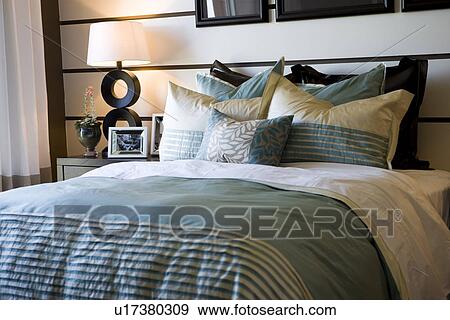 Stock Photo - Collection of pillows on bed. Fotosearch