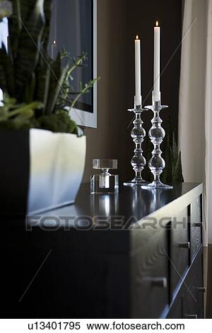 Stock Photography - Contemporary dresser with candlesticks and house plant. Fotosearch