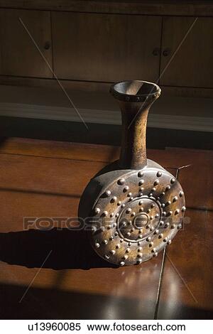 Stock Photography - Contemporary vase sitting on wooden table in sunlight. Fotosearch