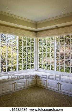 Stock Photography - Corner window with benches and cabinets. Fotosearch