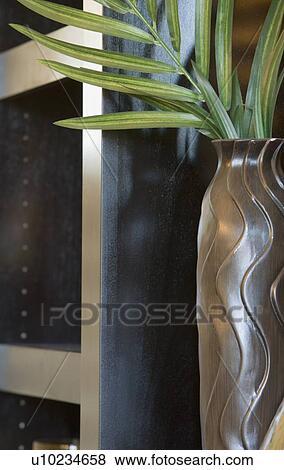 Stock Photo - Decorative vase on shelf with palm leaves. Fotosearch