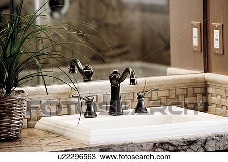 Stock Image - Detail bathroom sink with bronze faucet. Fotosearch