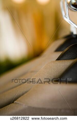 Stock Image - Detail men's suits hanging on rack. Fotosearch