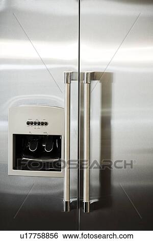 Stock Photograph - Detail of contemporary stainless steel refrigerator with water filter. Fotosearch