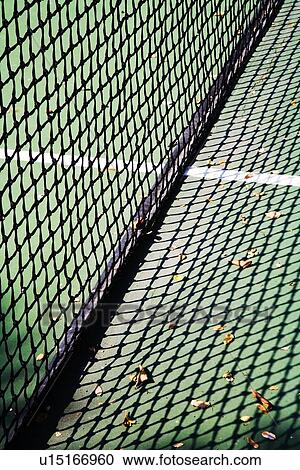Stock Image - Detail of net and shadow on tennis court. Fotosearch