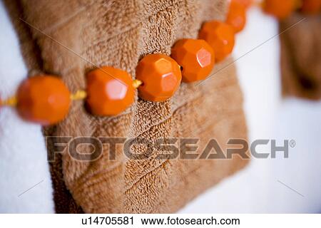 Detail of orange beads tied around brown hand towels View Large Photo Image Stock Image - Detail of orange beads tied around brown hand towels. Fotosearch