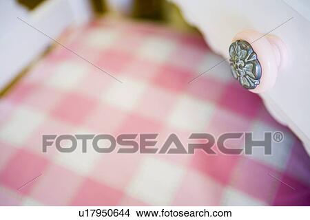 Detail pink drawer knob over pink gingham chair cushion View Large Photo Image Picture - Detail pink drawer knob over pink gingham chair cushion. Fotosearch