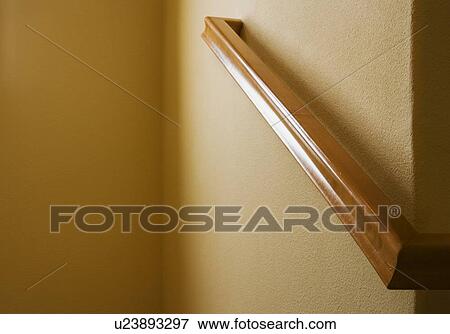 Stock Photo - Detail wooden handrail on wall. Fotosearch