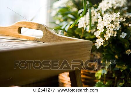 Stock Photo - Detail wooden serving tray and basket of flowers. Fotosearch