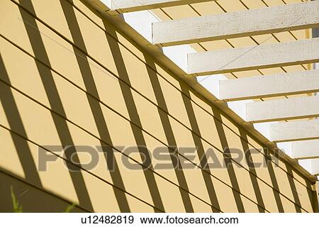 Stock Photo - Detail yellow home with white trellis. Fotosearch