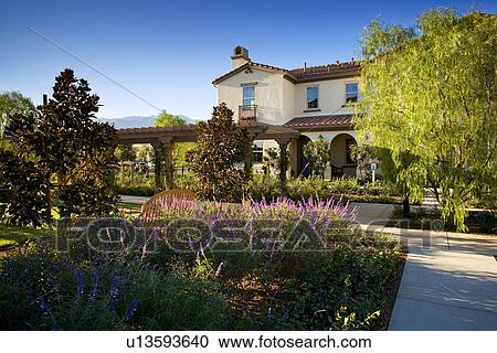 Exterior contemporary Spanish style home with lush gardens View Large Photo Image Stock Image - Exterior contemporary Spanish style home with lush gardens. Fotosearch