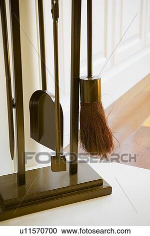 Stock Image - Fireplace accessory tool set near fireplace. Fotosearch