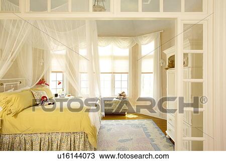 Girls Bedroom With Bay Window And Mosquito Netting Stock