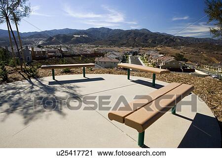 Stock Image - Group of benches overlooking housing community. Fotosearch