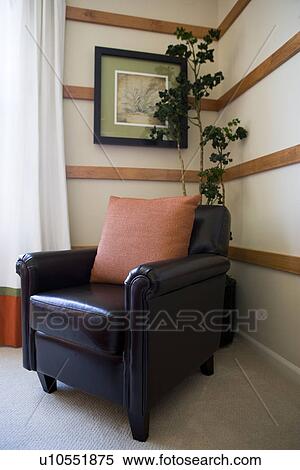 Leather armchair in corner with orange throw pillow View Large Photo Image Stock Photography - Leather armchair in corner with orange throw pillow. Fotosearch