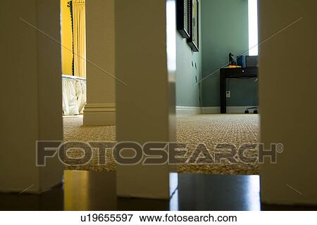 Stock Photo - Low angle view through banister posts into bedrooms. Fotosearch