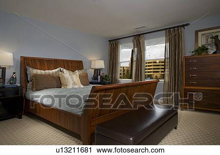 Stock Image - Masculine Blue Bedroom with Large Sleigh Bed. Fotosearch