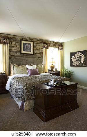Master bedroom with large bed and stone wall View Large Photo Image Stock Image - Master bedroom with large bed and stone wall. Fotosearch