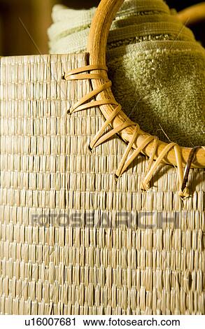 Stock Image - Natural beach bag with rolled towel inside. Fotosearch