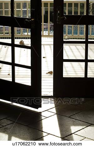 Stock Image - Open French doors leading to deck. Fotosearch