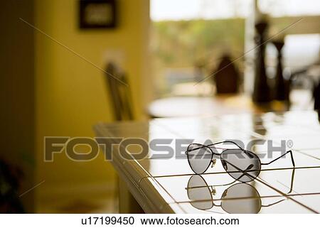 Pair of aviator sunglasses on tile kitchen counter View Large Photo Image Stock Image - Pair of aviator sunglasses on tile kitchen counter. Fotosearch