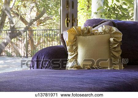 Stock Image - Purple chaise lounge with gold throw pillow. Fotosearch