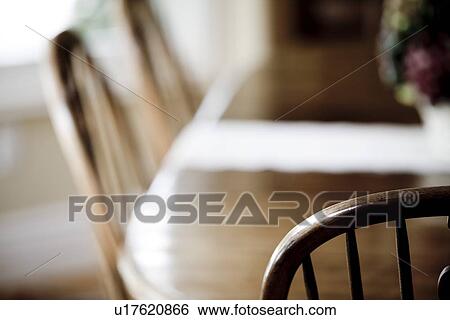 Stock Photograph - Selective focus captains chair at dining room table. Fotosearch