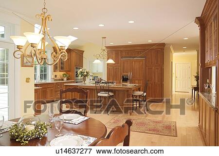 Stock Photo - Spacious traditional kitchen with wooden cabinets and dining area. Fotosearch