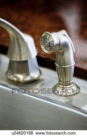 Stock Photo - Stainless steel kitchen sink faucet and sprayer. Fotosearch