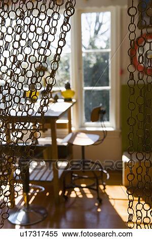 Stock Photography - Tall desk chair and desk in front of window behind ring curtain. Fotosearch