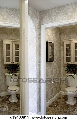 Toilet in bathroom with cabinet above and reflection in mirror View Large Photo Image Stock Image - Toilet in bathroom with cabinet above and reflection in mirror. Fotosearch