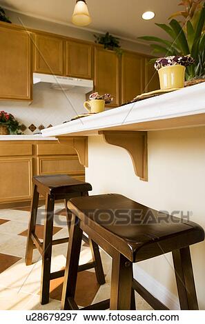 Two wooden stools at breakfast bar in kitchen View Large Photo Image Stock Photo - Two wooden stools at breakfast bar in kitchen. Fotosearch