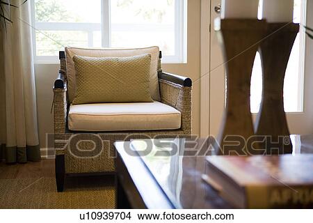 Picture - View of wicker armchair behind coffee table with candlesticks. Fotosearch