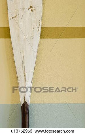 Wooden Oar Decoration Against Stripe Painted Wall Stock Image