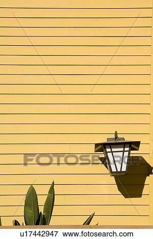 Stock Photo - Yellow siding with exterior lighting fixture. Fotosearch