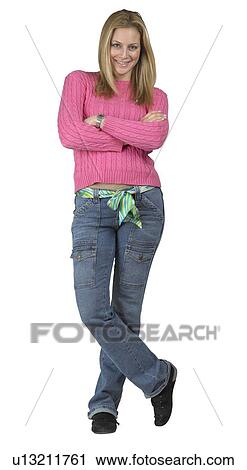 A young woman standing with her arms folded View Large Photo Image Stock Image - A young woman standing with her arms folded. Fotosearch