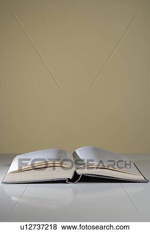 Stock Photo - An open book lying on a table. Fotosearch