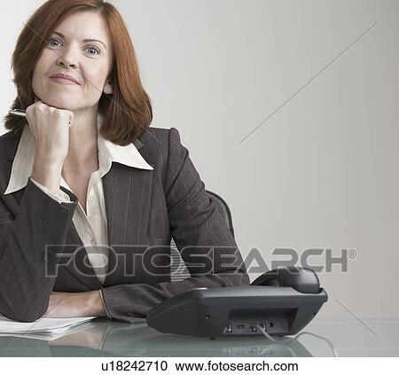 Attractive businesswoman with phone at desk View Large Photo Image Stock Image - Attractive businesswoman with phone at desk. Fotosearch