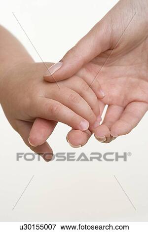 Stock Photo - Baby holding hands with mother. Fotosearch