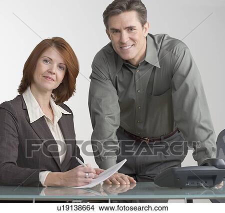 Business colleagues conferring at desk View Large Photo Image Picture - Business colleagues conferring at desk. Fotosearch