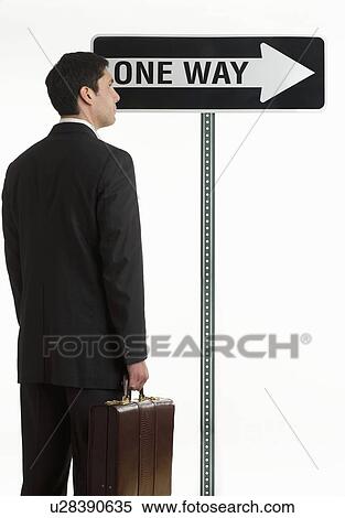 Businessman at one way sign View Large Photo Image Stock Photography - Businessman at one way sign. Fotosearch