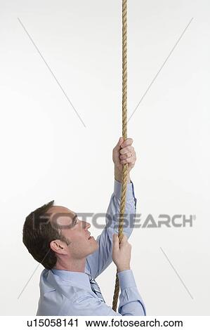 Stock Image - Businessman climbing a rope. Fotosearch
